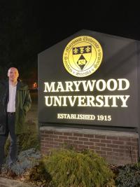 Marywood Criminal Justice Fulbright Lecturer in front of the Marywood Sign outside of the Nazareth Center Marywood University and Sunday in Harlem